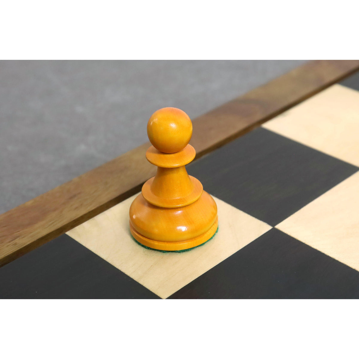 Detailed view of a weighted antiqued boxwood Pawn from the Fischer Dubrovnik chess collection.
