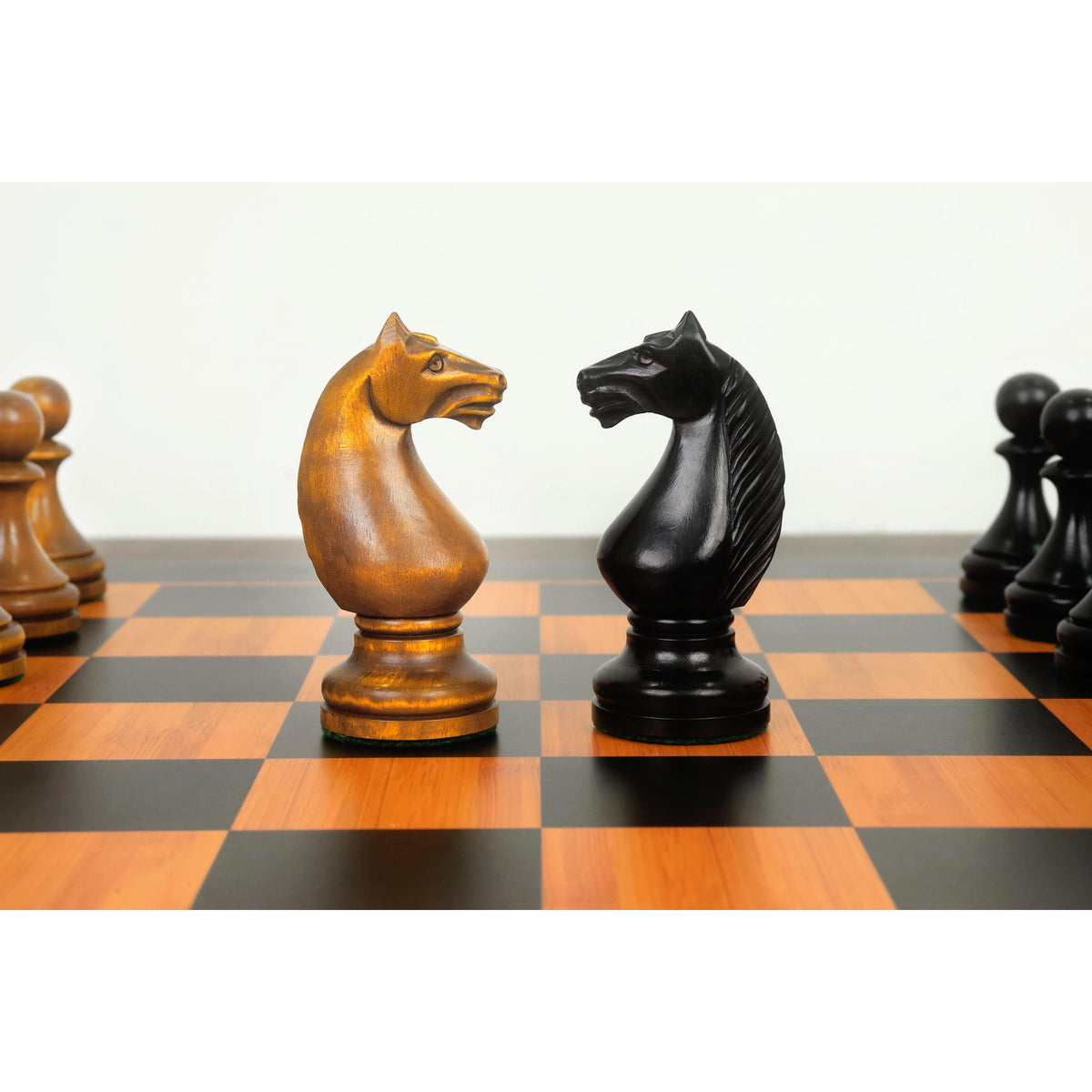 Distressed antiqued and ebonised boxwood Soviet Knights showing distinct manes and carved profiles.