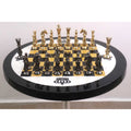 Reflective gold and black minimalist brass chess pieces arranged on a glossy checkered board.