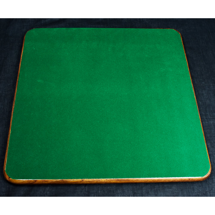 The bottom of a wooden chess board fully covered in protective green felt to prevent surface scratches.