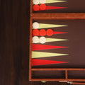 Close-up of the premium cognac brown leatherette texture and vibrant red and cream backgammon checkers.