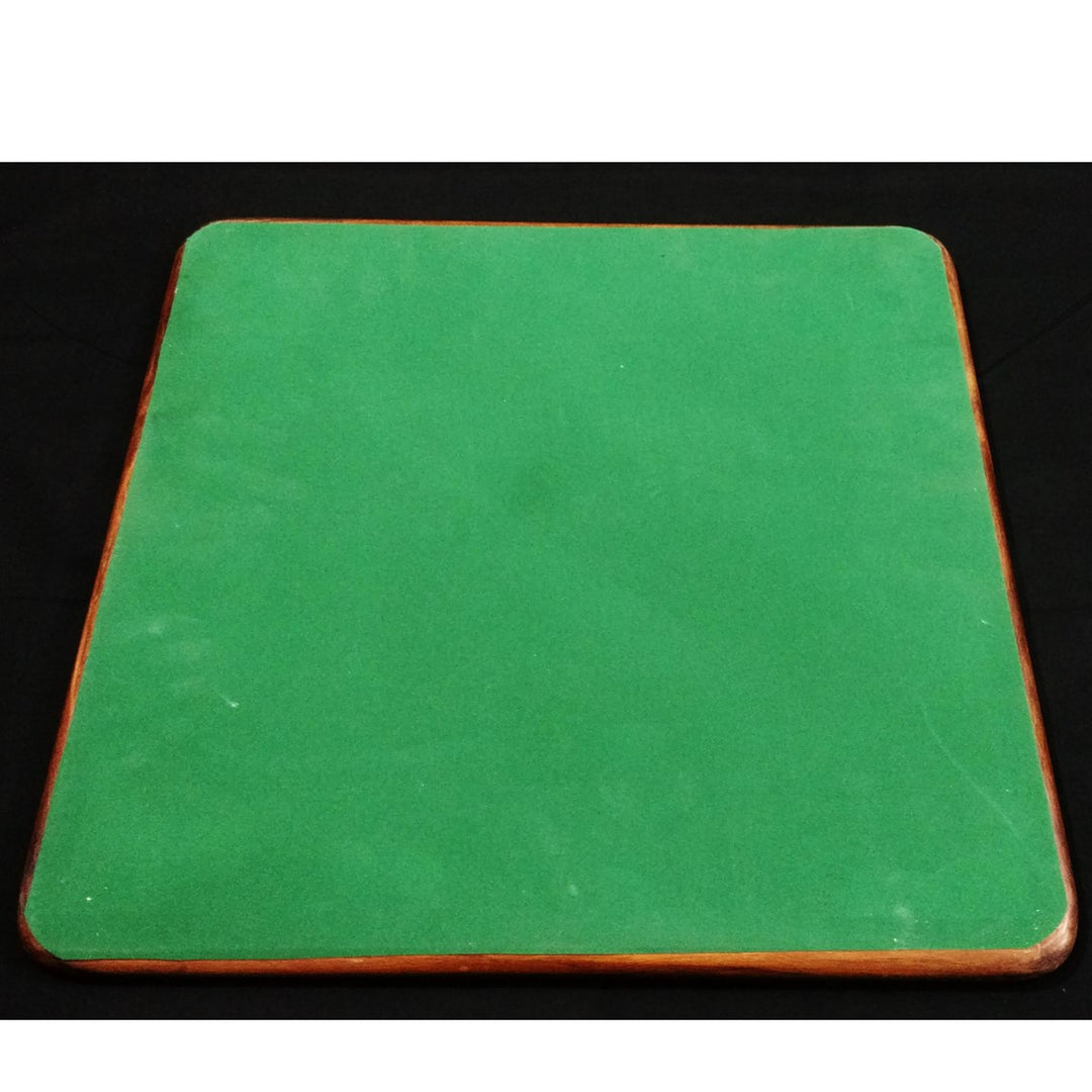 The underside of a wooden chess board featuring a protective green felt base to prevent scratches.