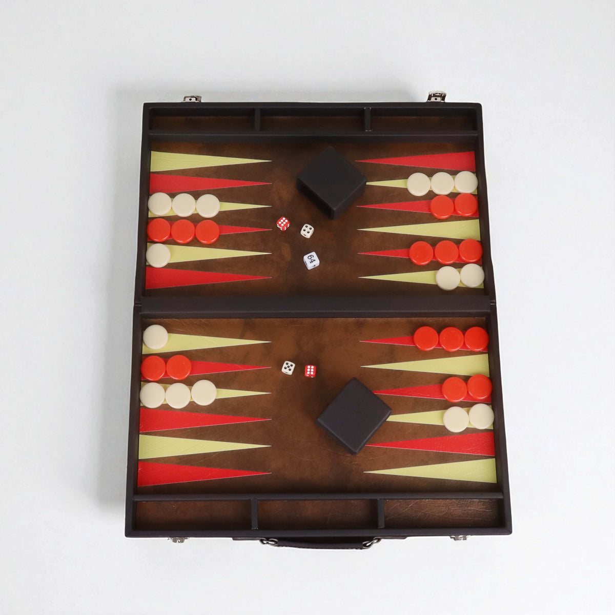 Top-down symmetrical view of the leatherette backgammon board with checkers and dice cups.