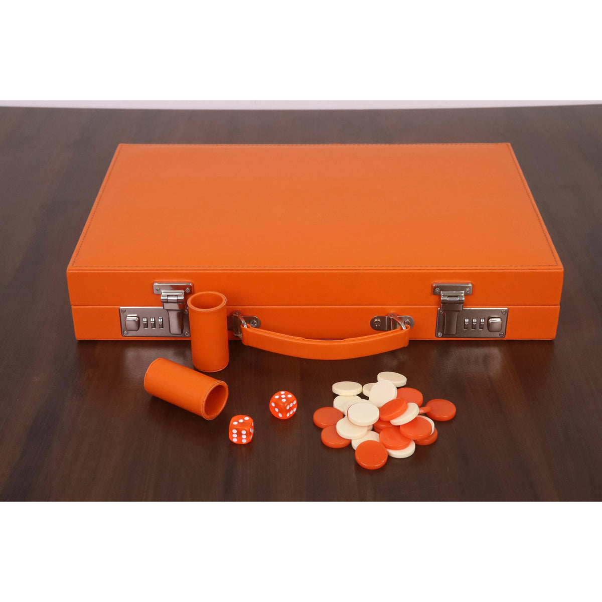 Closed orange leatherette backgammon briefcase with scattered game pieces and dice on a wooden table.