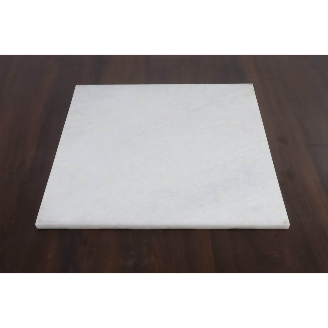 Solid white stone underside of the 15 inch luxury malachite chess board on a dark wood desk.