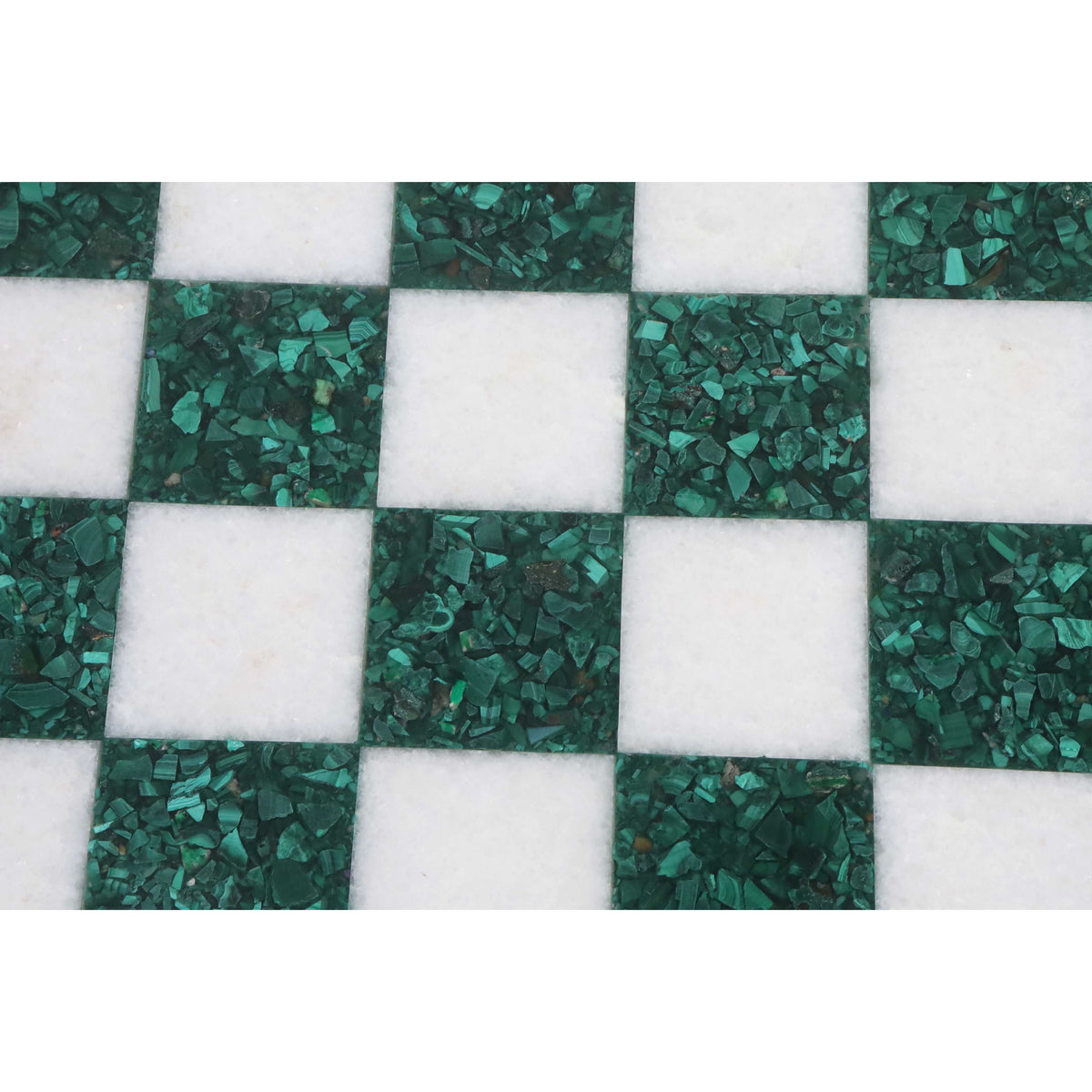 Close-up of crushed malachite green squares and white stone on a luxury borderless chess board.