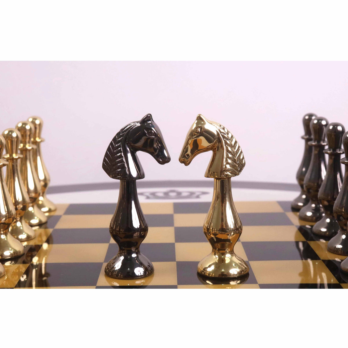 Gold brass and black nickel minimalist chess knights facing off on a luxury glossy chessboard.