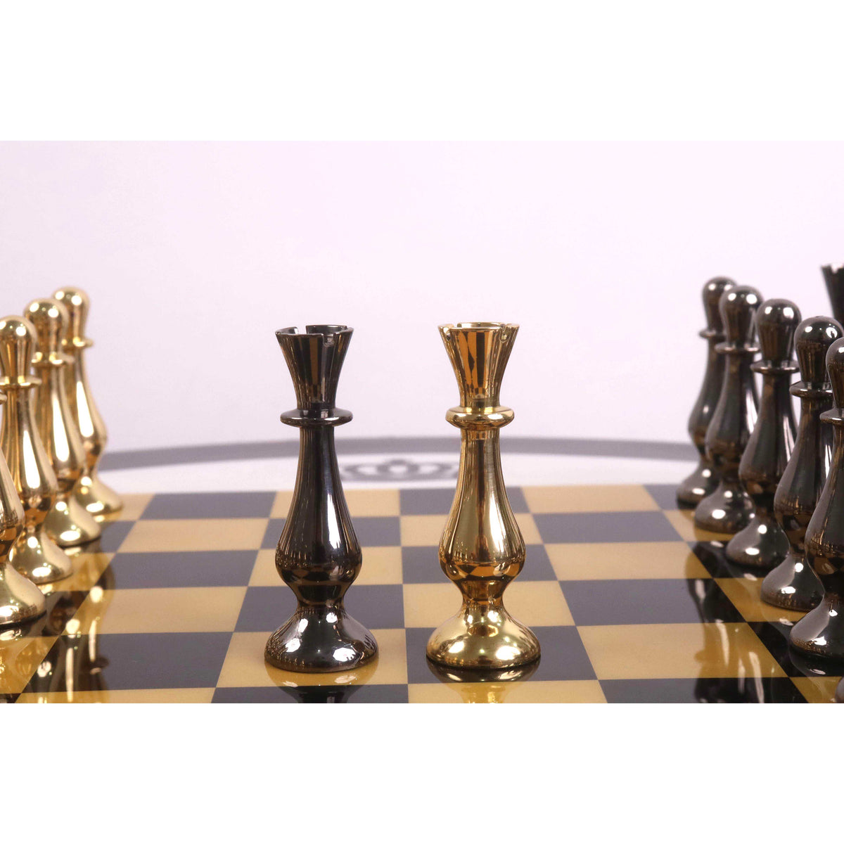 Modern black and gold minimalist brass rooks displayed on a gloss finish chess board.