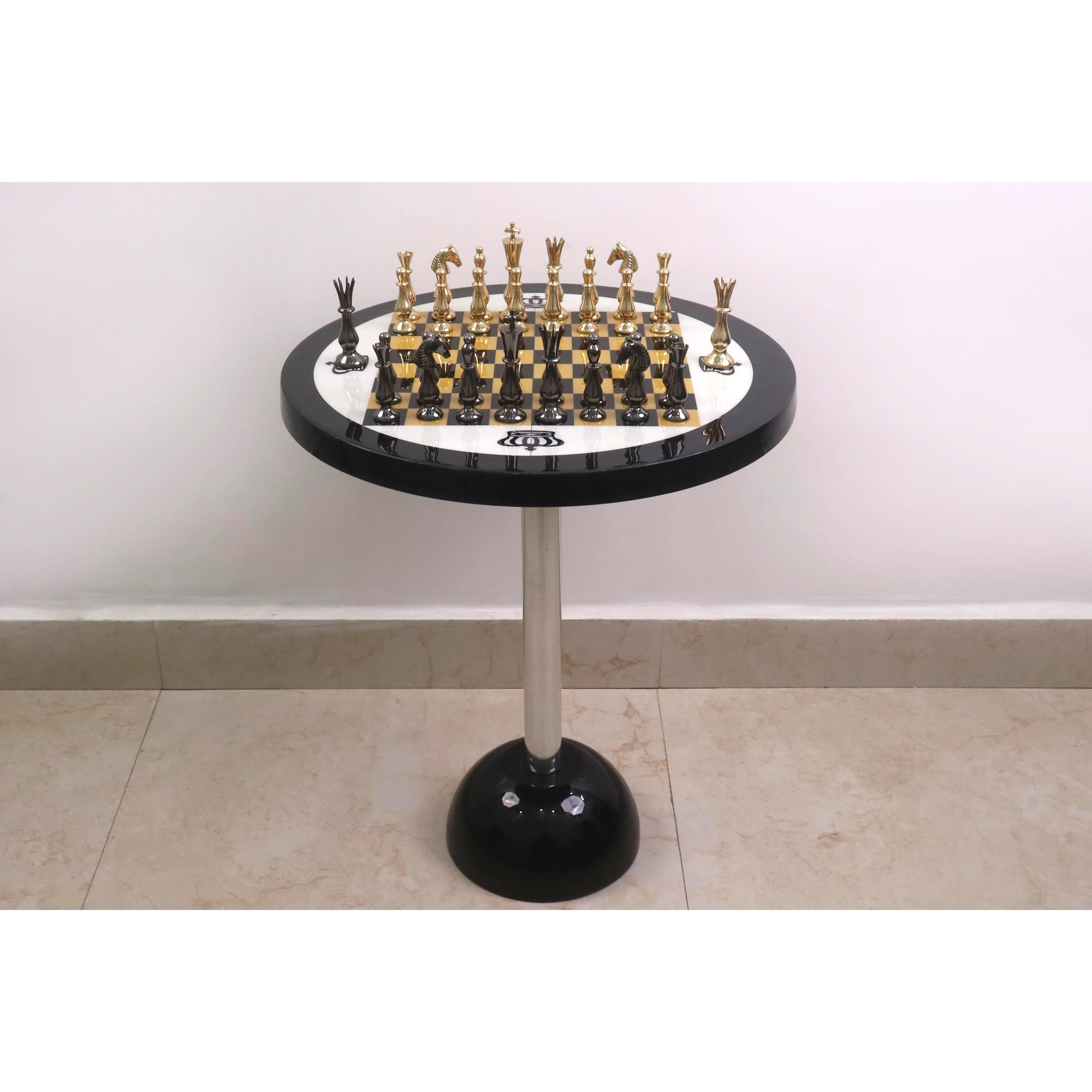 Minimalist luxury metal chess set featuring gold and black pieces on a matching pedestal table.