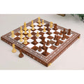Golden rosewood and acrylic ivory chess pieces positioned mid-game on an inlaid folding wooden board.