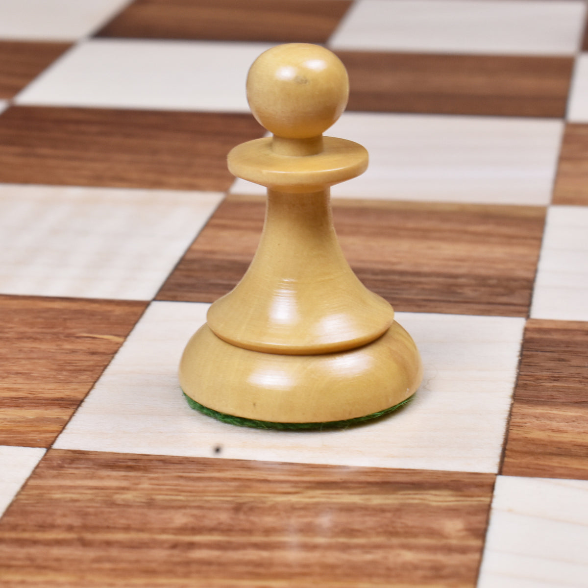 Natural boxwood pawn from the 1950s Soviet Latvian reproduction set showing the curved base and slim collar.