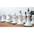 Low-angle shot of white lacquer Soviet reproduction chess pieces showing the unique king and queen finials.