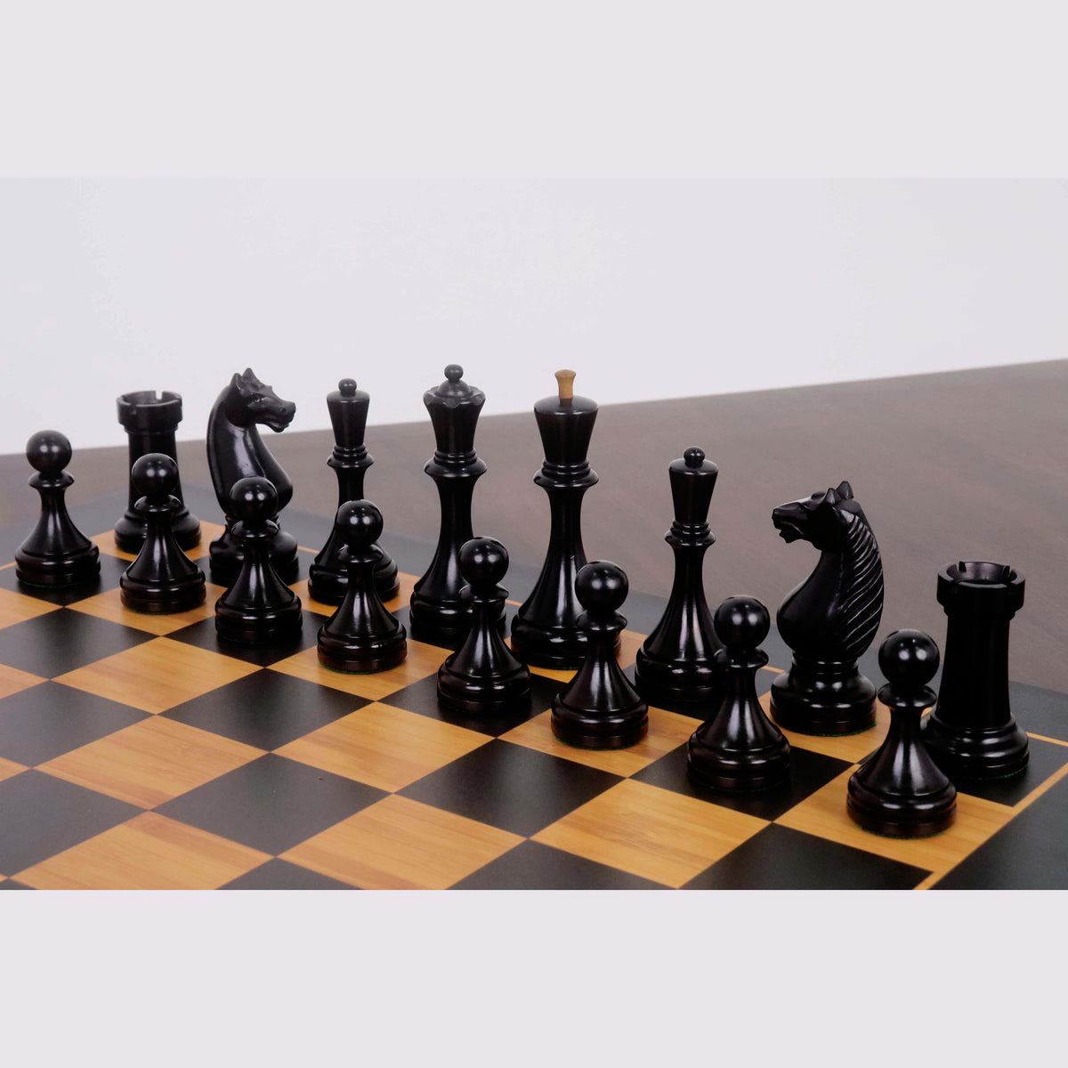 Ebonised boxwood Soviet chess pieces from the 1935 Botvinnik Flohr-II set arranged on a board.
