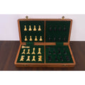 Green felted interior of a wooden chess box with custom storage slots for ebonized and boxwood pieces.