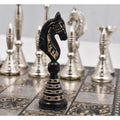 Close-up of the black brass Warli artwork knight chess piece with soft background.