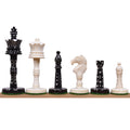 Alternating black and white camel bone Victorian era pre-Staunton chess pieces lined up on a wooden surface.