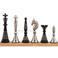 Complete set of solid brass black and silver Warli art chess pieces in a studio view.