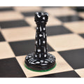 Black dyed camel bone Victorian era pre-Staunton rook piece displaying detailed circular carvings on a chessboard.