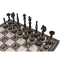 Overhead view of the black brass Warli art chess army arranged on the board.
