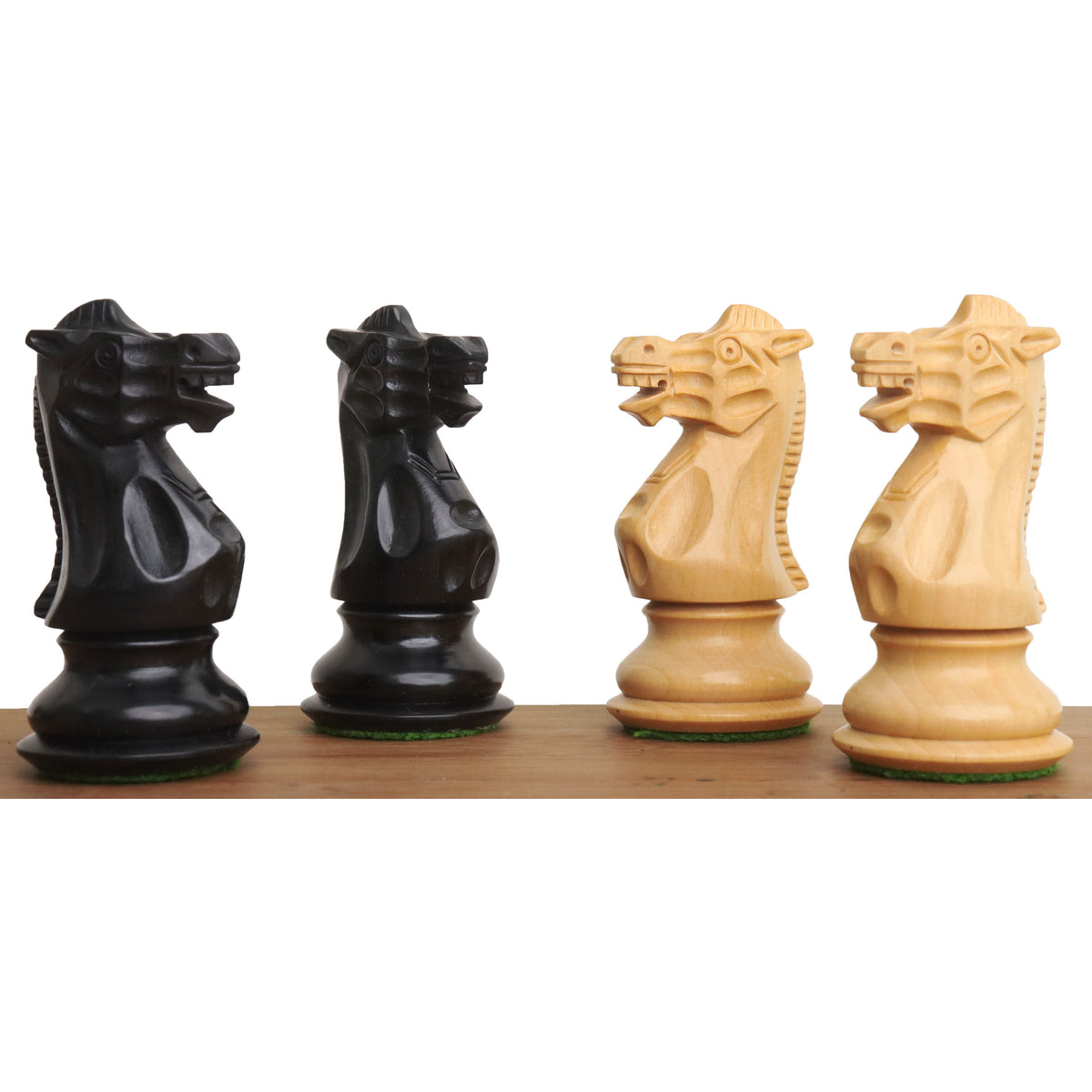 Four knight pieces from the 3.7" British Staunton ebonised boxwood chess set, displaying detailed carving.