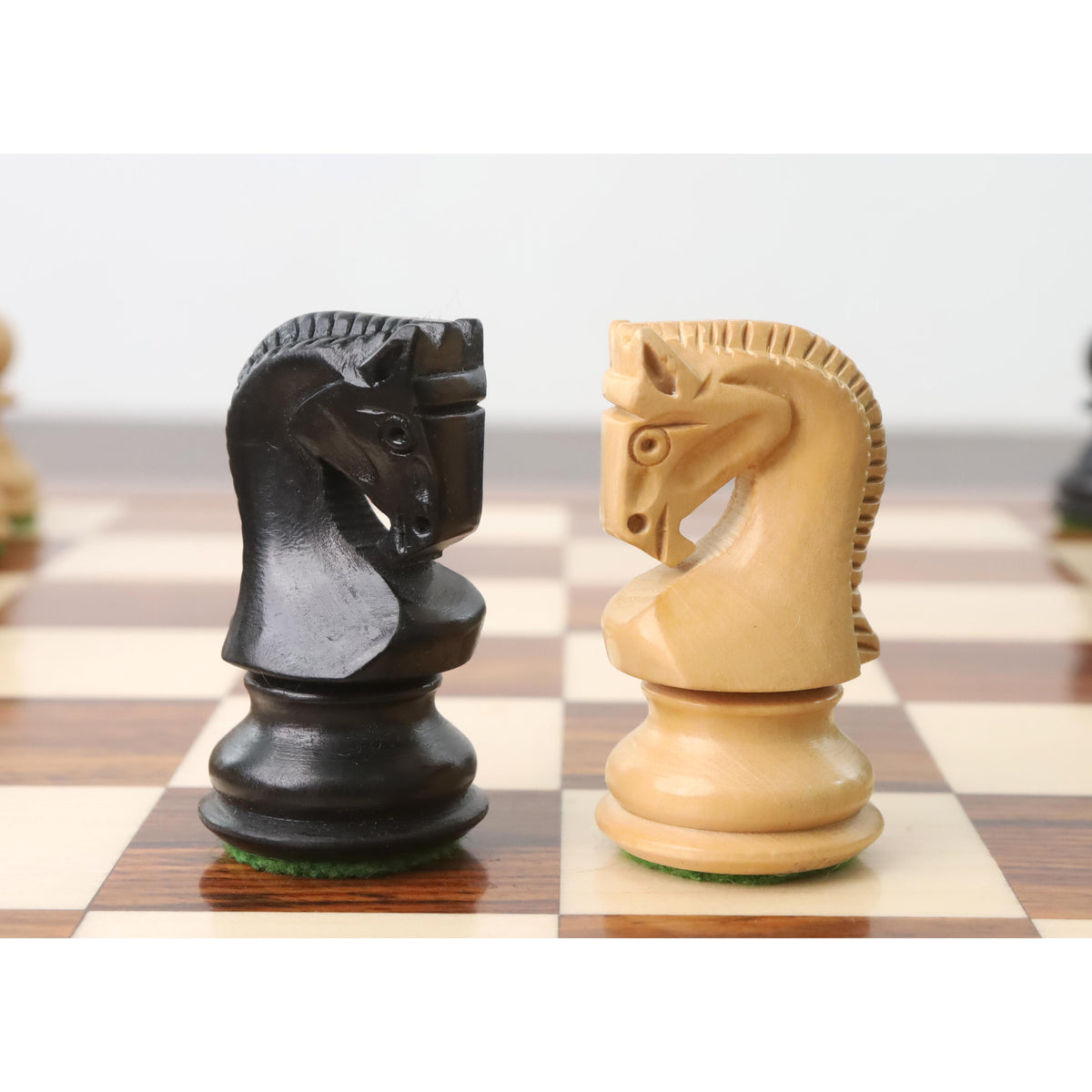 Detailed view of the uniquely carved knights from the Russian Zagreb chess set on a wooden board.