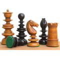 Close up of antique Calvert chess pieces in ebony and boxwood with a fallen pawn showing its green felted base.