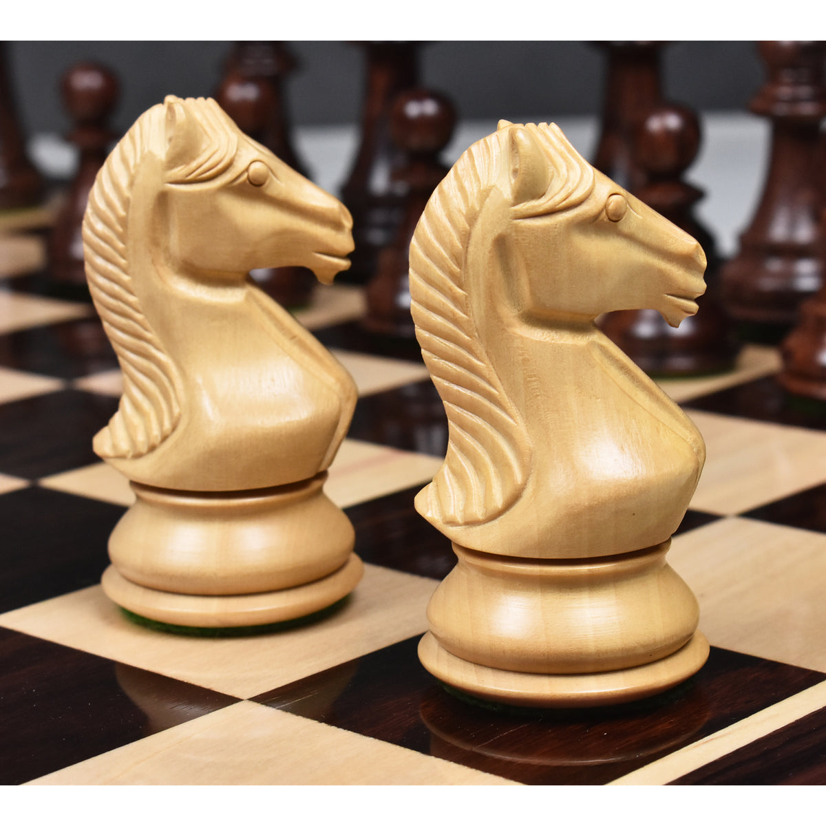 Detailed profile view of two natural boxwood knights from the Majestic Series Staunton chess set.