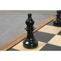 A black ebonized boxwood W.T. Pinney Staunton bishop with a traditional slotted miter on a chessboard.