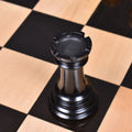 Black ebony wood Mogul Staunton rook piece on a chessboard.
