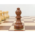 Golden rosewood bishop chess piece displaying clean wood grain on a tournament wooden chessboard.