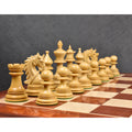 Row of hand-carved natural boxwood Napoleon style luxury chess pieces on a glossy wood board.