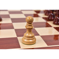 Close-up view of a light boxwood Staunton pawn piece on a board.