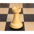 Elegant triple-weighted boxwood rook chess piece on a wooden board.
