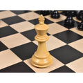 A single natural boxwood Staunton chess king displayed on a wooden board.