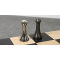 High-resolution close-up of the silver and dark antique finish brass luxury chess pawns on a marble square.