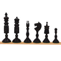 Dark antique pre-Staunton chess pieces arranged on a wooden surface.