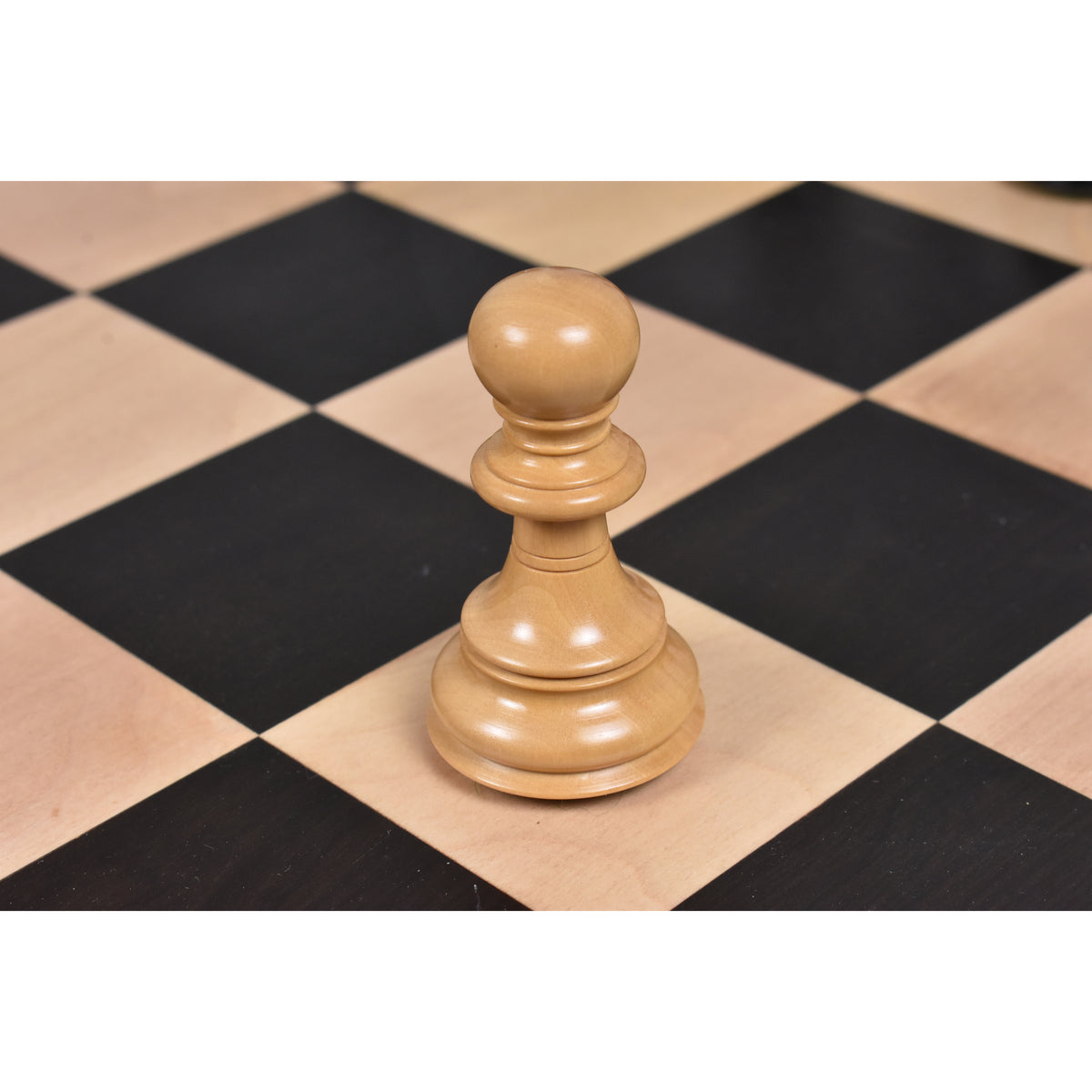 Single light boxwood Staunton pawn piece centered on a professional wooden chessboard.