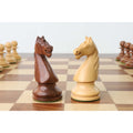 Golden rosewood and boxwood French Grandmaster knight pieces facing off.