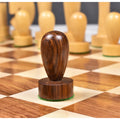 Sleek golden rosewood minimalist pawn piece standing on a wooden chessboard square.