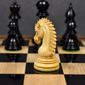 Intricately carved boxwood knight piece showcasing its detailed mane profile on a wooden chess board.