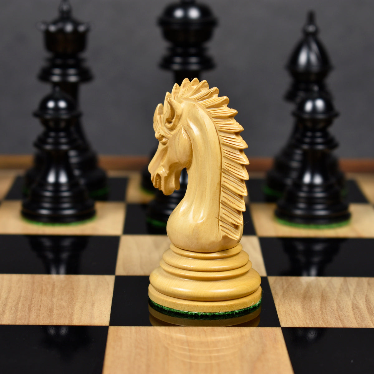 Intricately carved boxwood knight piece showcasing its detailed mane profile on a wooden chess board.