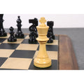 A natural boxwood W.T. Pinney Staunton King stands prominently on a chessboard with dark pieces blurred in the background.