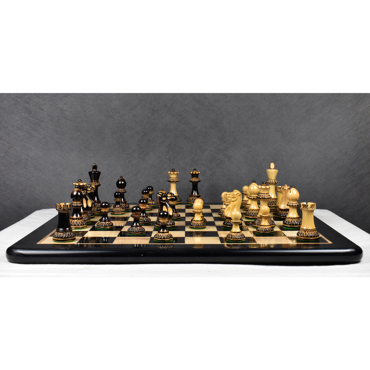 Full setup of the 3.9 inch Parker Staunton carved chess pieces on a black and maple board.