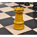 Antiqued boxwood rook showing clean tiered ridges on a classic wooden chessboard.