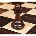 Close-up of a dark rosewood Imperial Staunton pawn standing on a glossy chessboard.