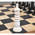 Minaret series ivory white camel bone queen chess piece with tiered finial on a wooden board.