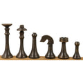Complete line of dark antique brass luxury chess pieces standing on a wooden base.