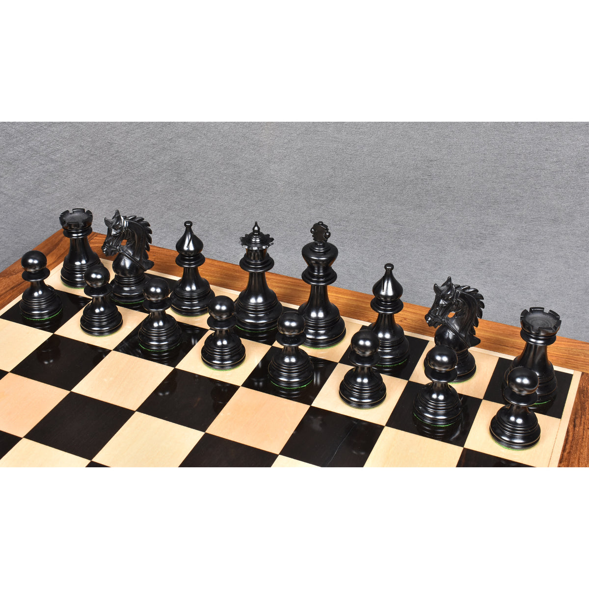 Handcrafted triple weighted ebony wood chess pieces from the Napoleon luxury series set up on board.