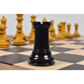 Black ebony Harrwitz Staunton rook chess piece standing on a wooden board.
