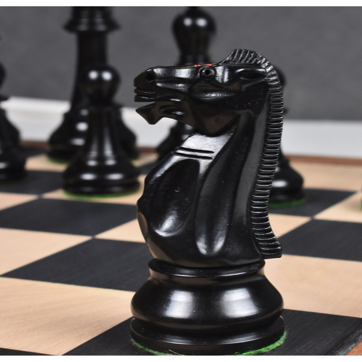 Close-up profile of a hand-carved natural ebony wood knight piece from the Lessing series.